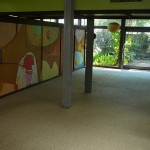 A view from den area into living area.  The large mural hides storage for media, books, display, etc.  The mural was painted in 1969 by Robert Madden.