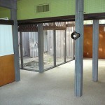 A view from living room into den area showing the atrium and front entrance to the house.